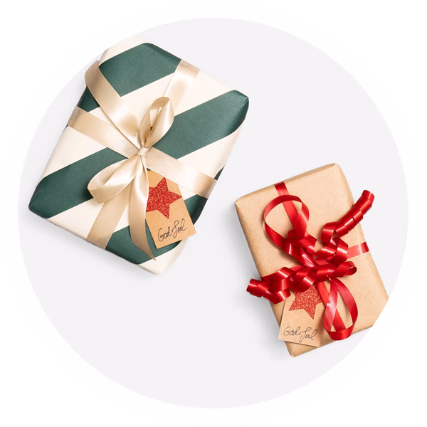 Två inslagna julklappar med lappar på med en röd stjärna och texten "God Jul".